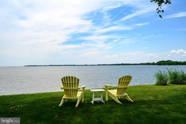 a view of a lake with table and chairs