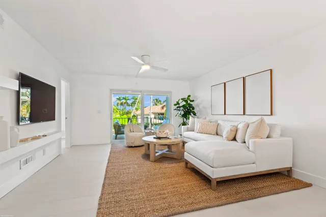a living room with furniture a couch and a potted plant