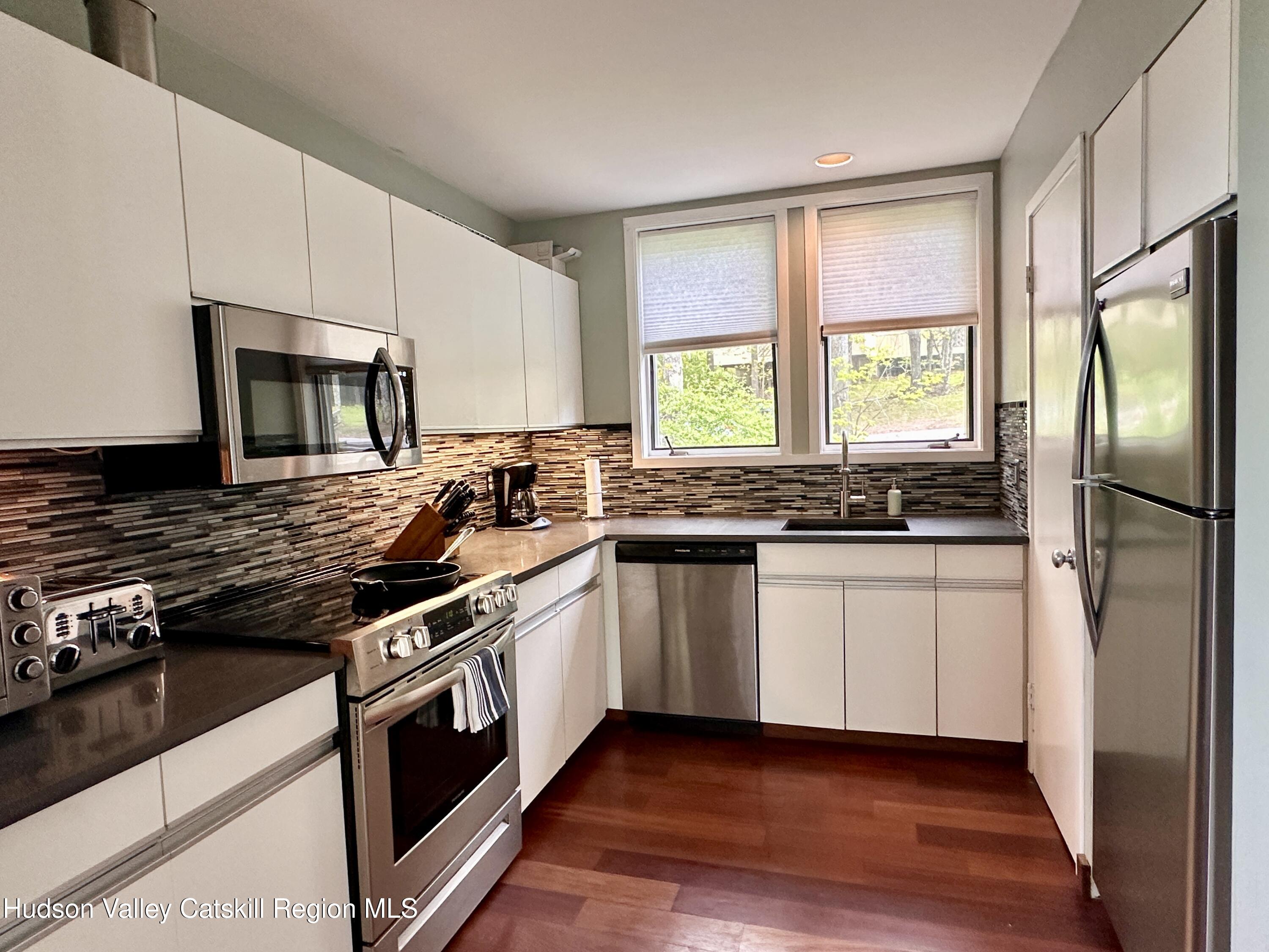 270 Pines Drive, Unit 92 Roxbury, NY 12421 - Photo 8 of 31 a kitchen with stainless steel appliances granite countertop a stove a sink and a refrigerator