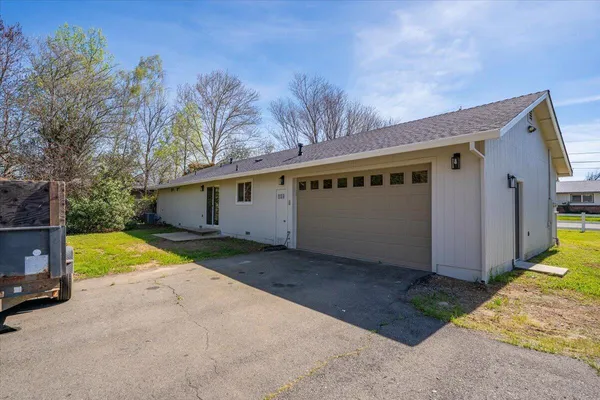 a view of a house with backyard and trees