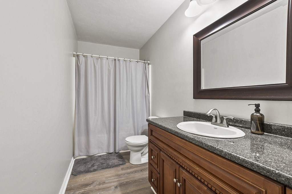 305 North Main Street Raynham, MA 02767 - Photo 19 of 38 a bathroom with a granite countertop sink toilet and mirror