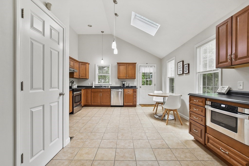 305 North Main Street Raynham, MA 02767 - Photo 8 of 38 a kitchen with stainless steel appliances granite countertop a refrigerator and a stove top oven