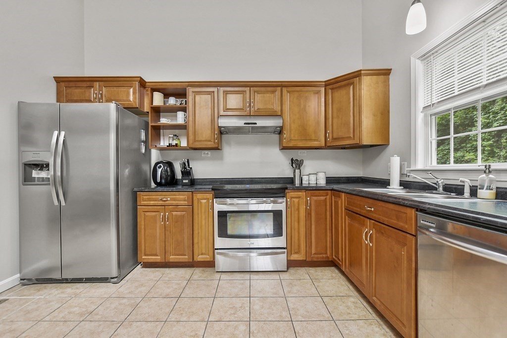 305 North Main Street Raynham, MA 02767 - Photo 10 of 38 a kitchen with stainless steel appliances granite countertop a refrigerator and a sink