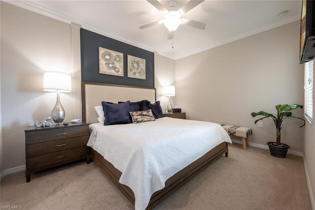 9572 Trevi Court, Unit 5045 Naples, FL 34113 - Photo 14 of 30 a bedroom with bed and a chandelier