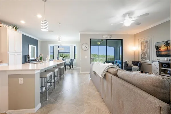 a living room with furniture a flat screen tv and a large window