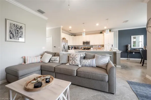 a living room with furniture and kitchen view
