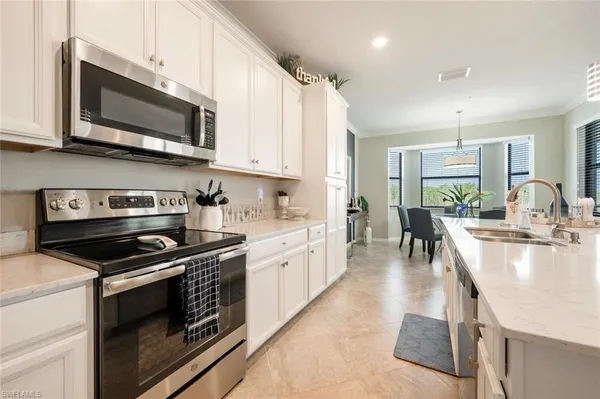 a large kitchen with stainless steel appliances granite countertop a stove a sink and a microwave