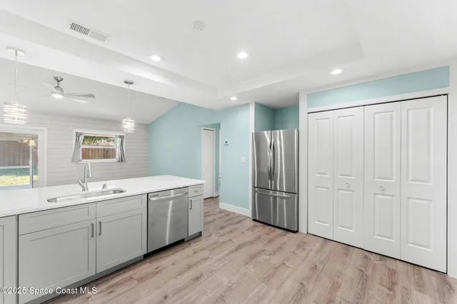 a view of a kitchen with stainless steel appliances granite countertop a refrigerator and a sink