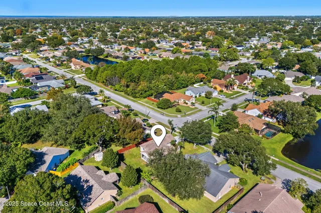 an aerial view of residential houses with outdoor space and trees