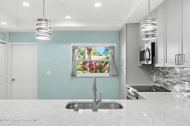 a view of a kitchen with granite countertop a sink and chandelier
