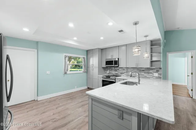 a kitchen with sink refrigerator and microwave