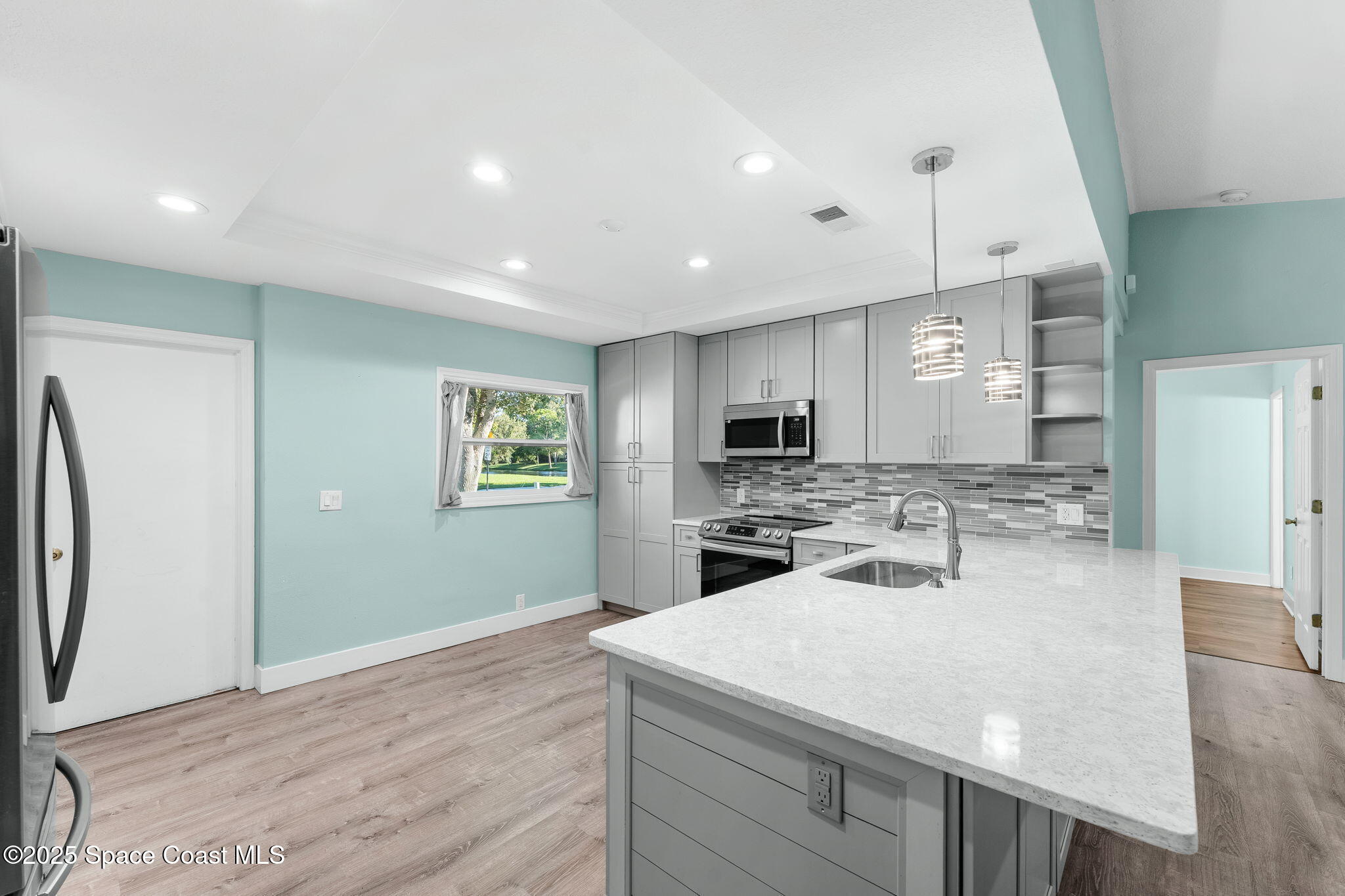955 Sabal Grove Drive Rockledge, FL 32955 - Photo 9 of 39 a kitchen with sink refrigerator and microwave