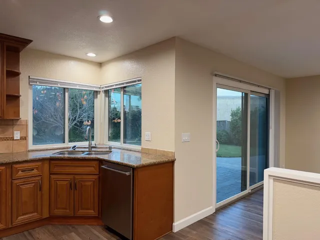 a open kitchen with granite countertop sink and cabinets