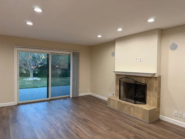a view of empty room with wooden floor and fireplace