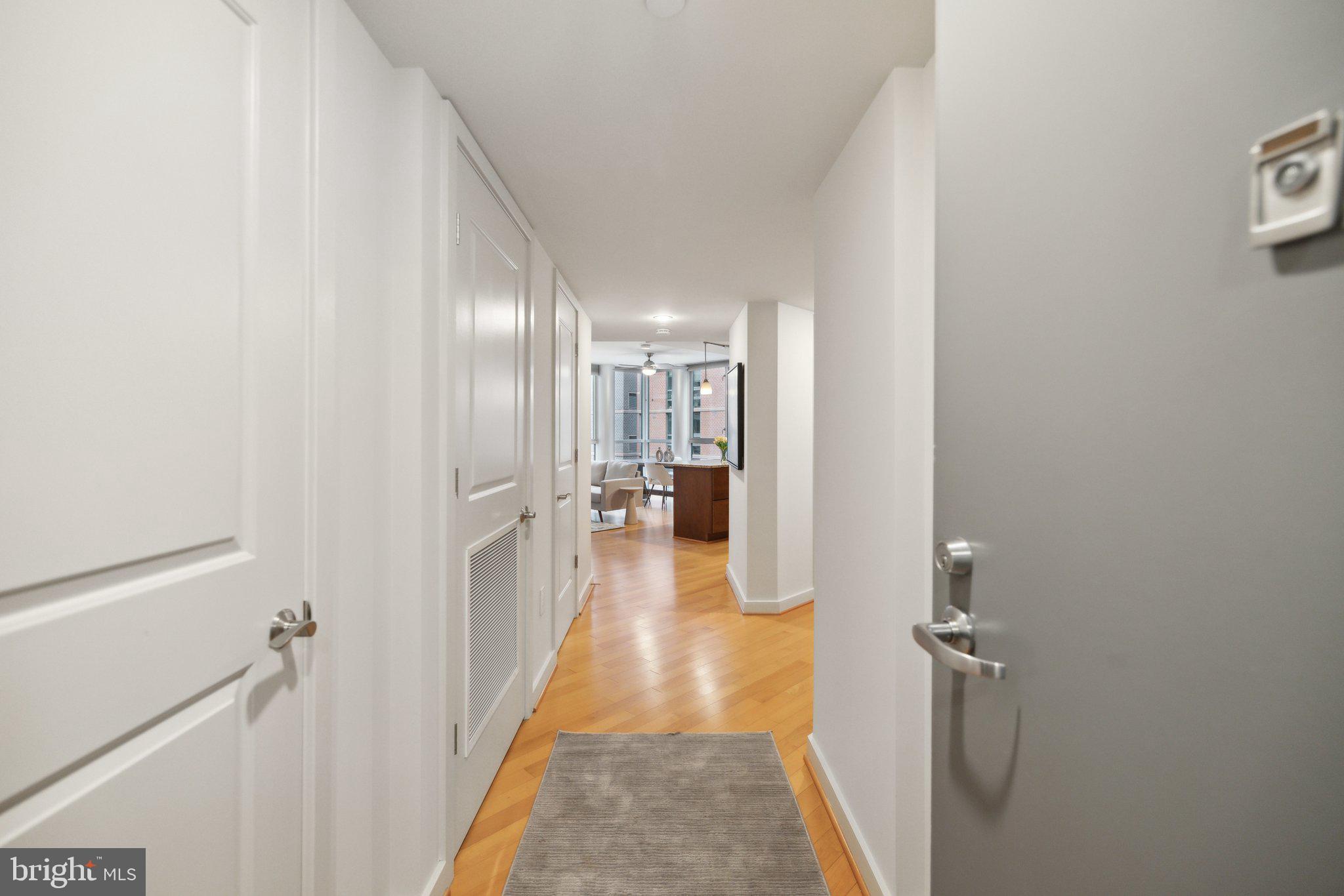 1025 First Street Southeast, Unit 716 Washington, DC 20003 - Photo 2 of 27 a view of a hallway with wooden floor and a bathroom