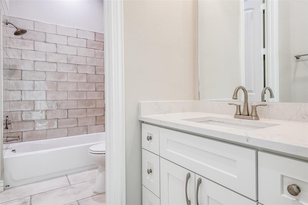 13929 Jackson Road Ponder, TX 76259 - Photo 11 of 16 a bathroom with a granite countertop sink a toilet and bathtub