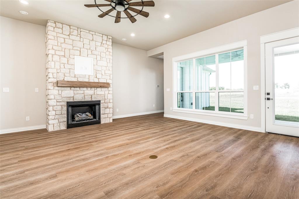 13929 Jackson Road Ponder, TX 76259 - Photo 7 of 16 a view of an empty room with wooden floor fireplace and a window