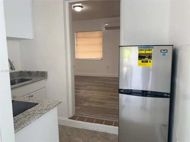 a bathroom with a granite countertop sink and a shower