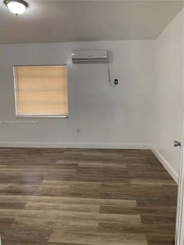 a view of a small space with wooden floor and a window