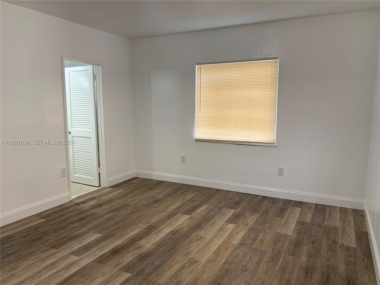6290 Southwest 39th Street Miami, FL 33155 - Photo 9 of 12 an empty room with wooden floor and windows