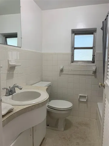 a white toilet sitting next to a bathroom sink