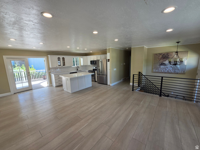 6123 Rodeo Lane Murray, UT 84121 - Photo 11 of 20 Open-concept living area featuring wood-finish flooring, recessed lighting, and a modern kitchen
