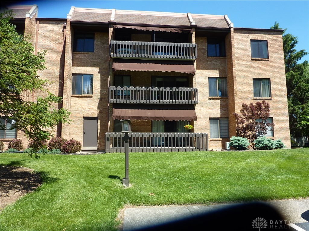 1345 Tattersall Road, Unit 64 Dayton, OH 45459 - Photo 2 of 25 This multi-story brick building features balconies with awnings, complemented by well-maintained landscaping.