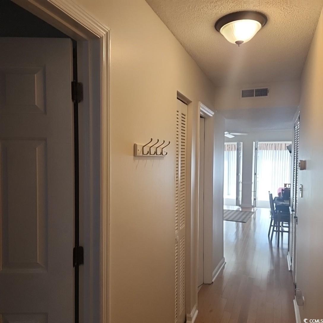 1300 Deer Creek Road, Unit C Surfside Beach, SC 29575 - Photo 3 of 18 Hall featuring dark wood finished floors and a textured ceiling