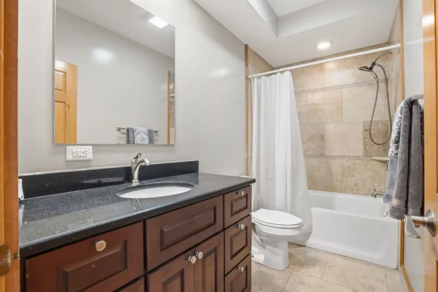 a bathroom with a granite countertop sink toilet and shower