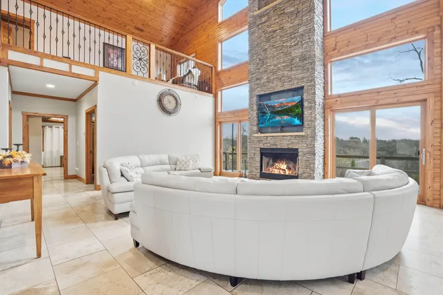 a living room with fireplace furniture and a floor to ceiling window