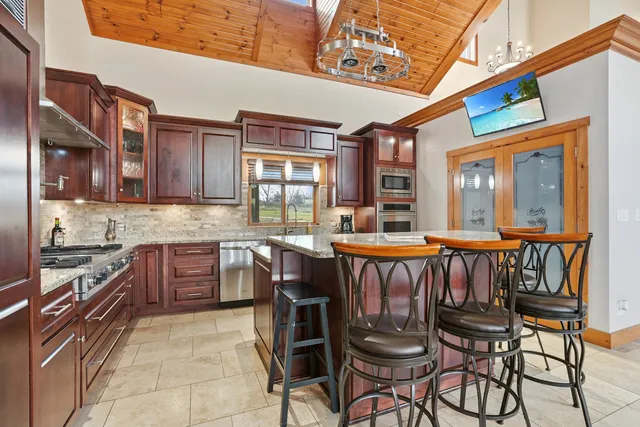 a kitchen with a dining table chairs cabinets and stainless steel appliances