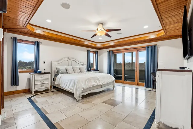 a spacious bedroom with a large bed and a chandelier