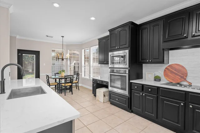 a kitchen with stainless steel appliances kitchen island granite countertop a stove refrigerator and cabinets