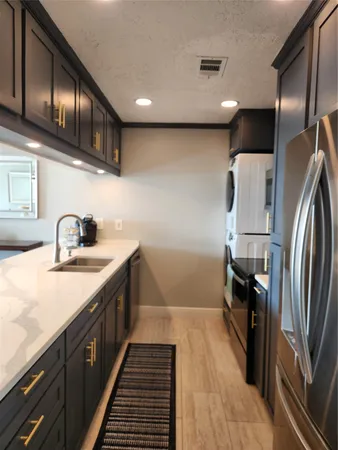 a metallic refrigerator freezer sitting inside of a kitchen