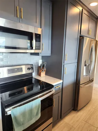 a kitchen with stainless steel appliances granite countertop a refrigerator and a stove