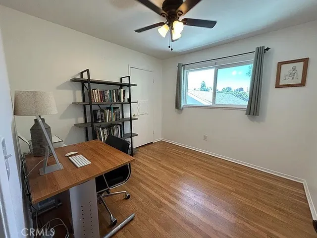 a view of a workspace with furniture and a window