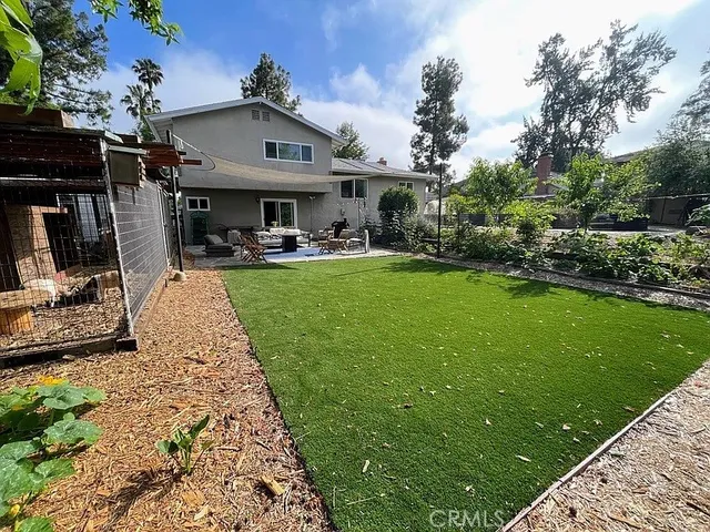 a view of a house with garden bath tub and trees in the background
