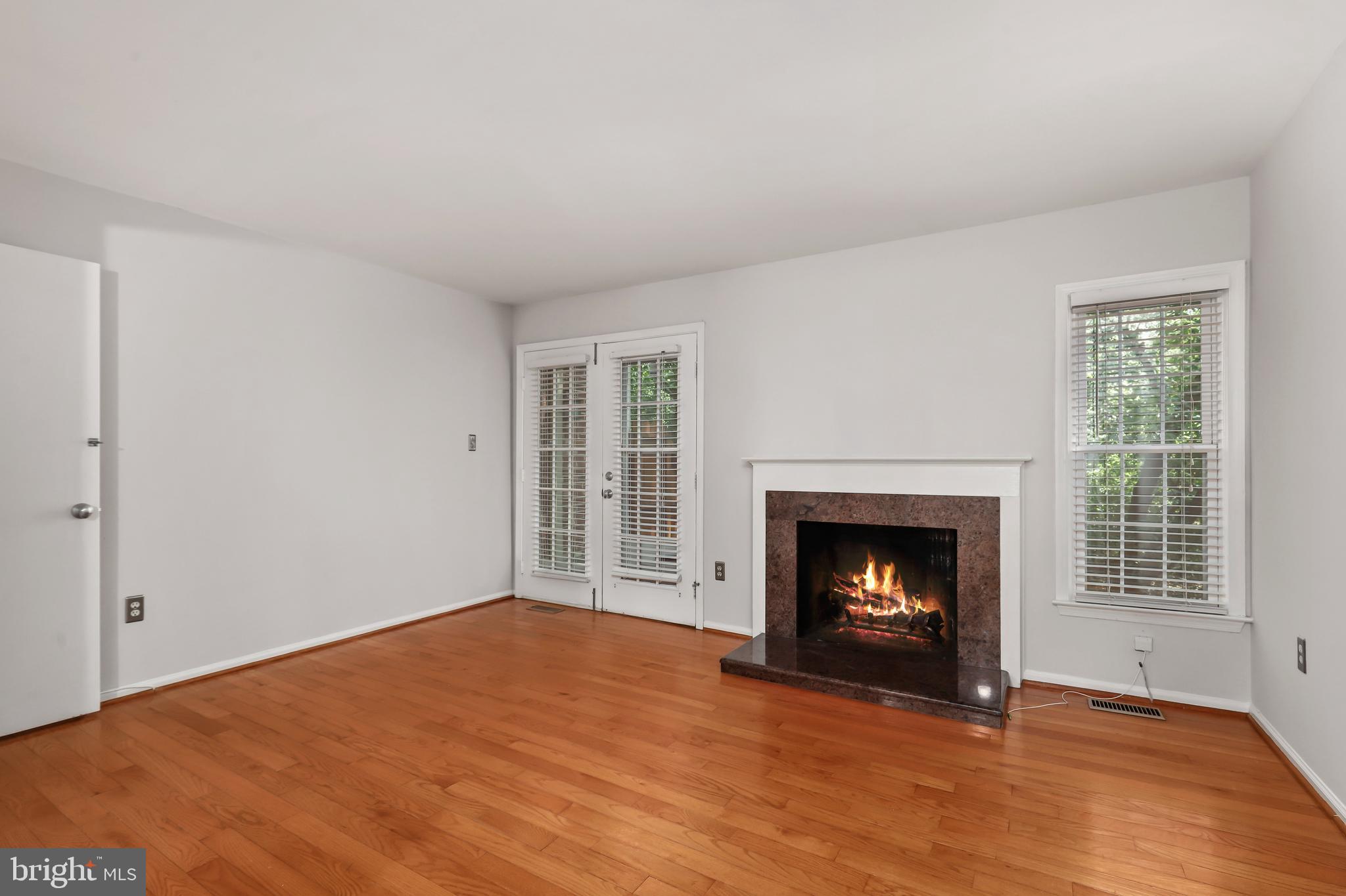 2434 South Walter Reed Drive, Unit 3 Arlington, VA 22206 - Photo 11 of 36 a view of an empty room with wooden floor fireplace and a window