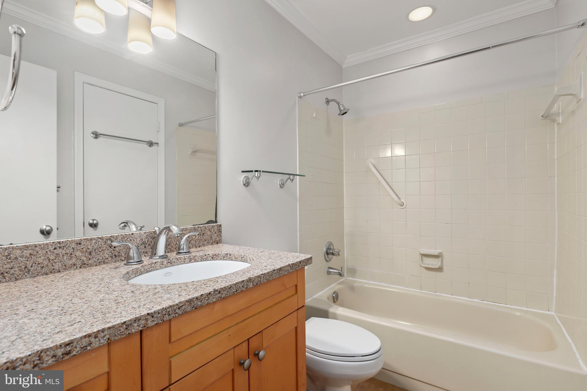 2434 South Walter Reed Drive, Unit 3 Arlington, VA 22206 - Photo 17 of 36 a bathroom with a granite countertop sink a toilet and shower