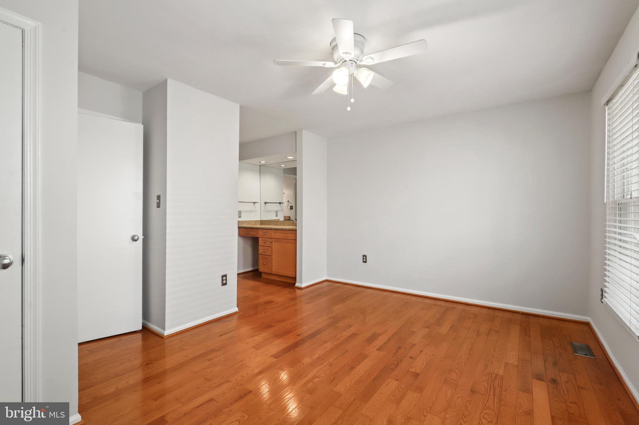 2434 South Walter Reed Drive, Unit 3 Arlington, VA 22206 - Photo 18 of 36 wooden floor in an empty room with a kitchen