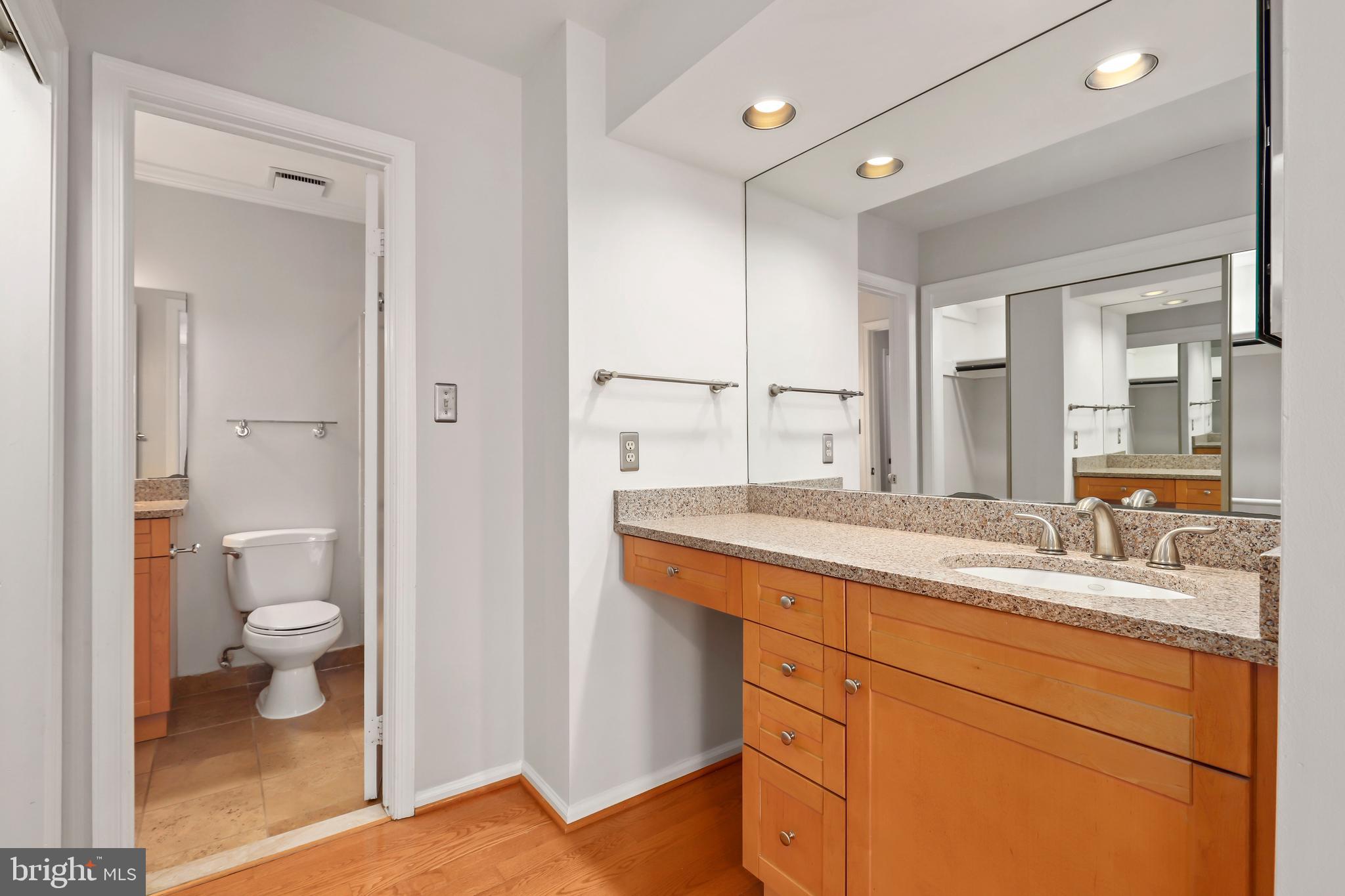 2434 South Walter Reed Drive, Unit 3 Arlington, VA 22206 - Photo 22 of 36 a bathroom with a granite countertop sink mirror and a toilet