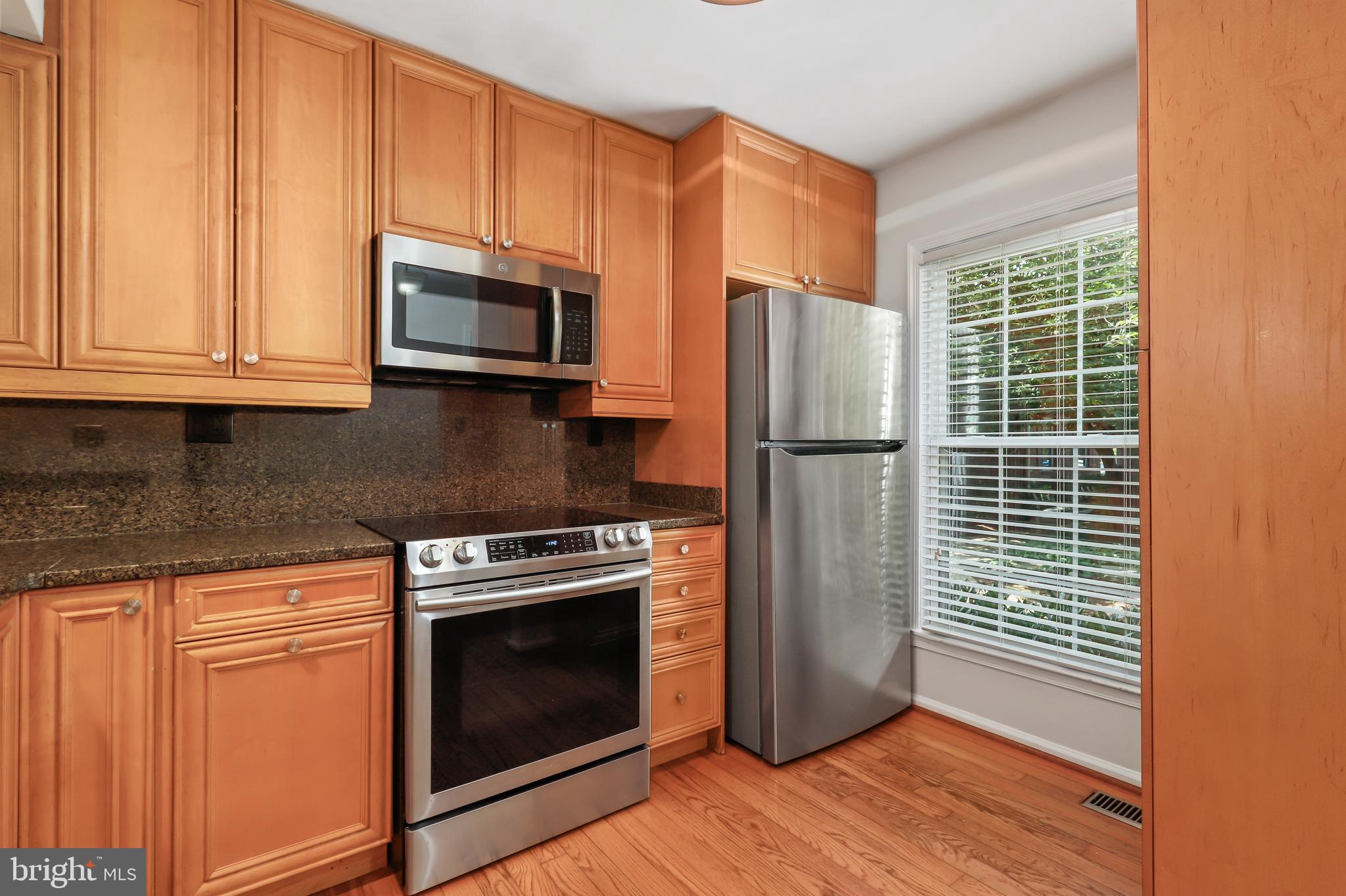 2434 South Walter Reed Drive, Unit 3 Arlington, VA 22206 - Photo 4 of 36 a kitchen with granite countertop wooden cabinets stainless steel appliances and a window
