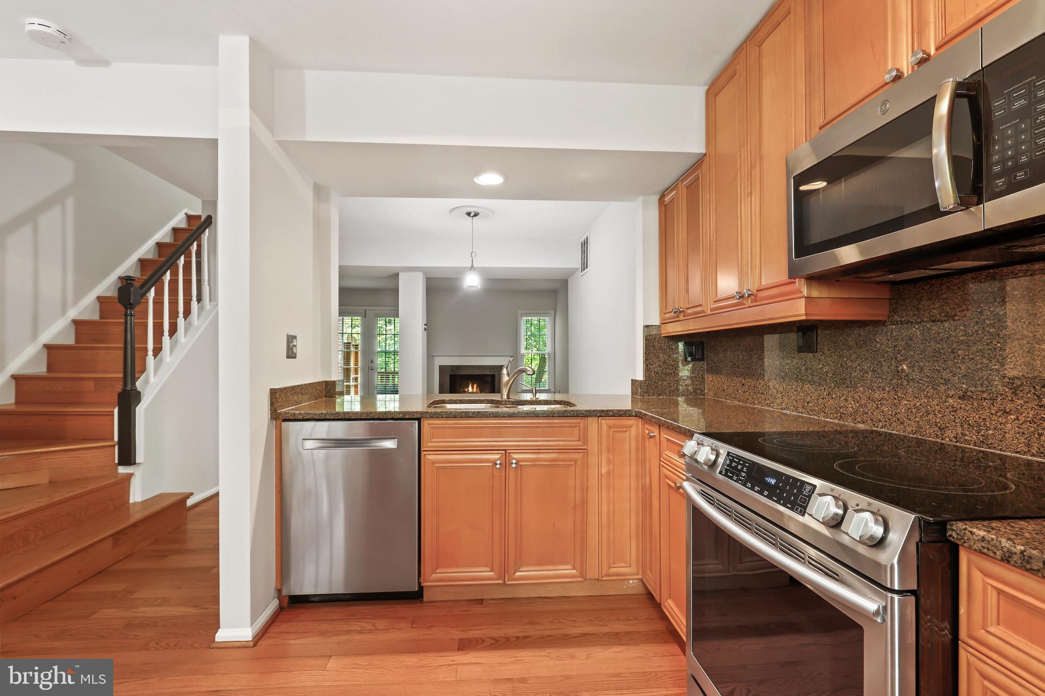 2434 South Walter Reed Drive, Unit 3 Arlington, VA 22206 - Photo 5 of 36 a kitchen with stainless steel appliances granite countertop a stove and a microwave