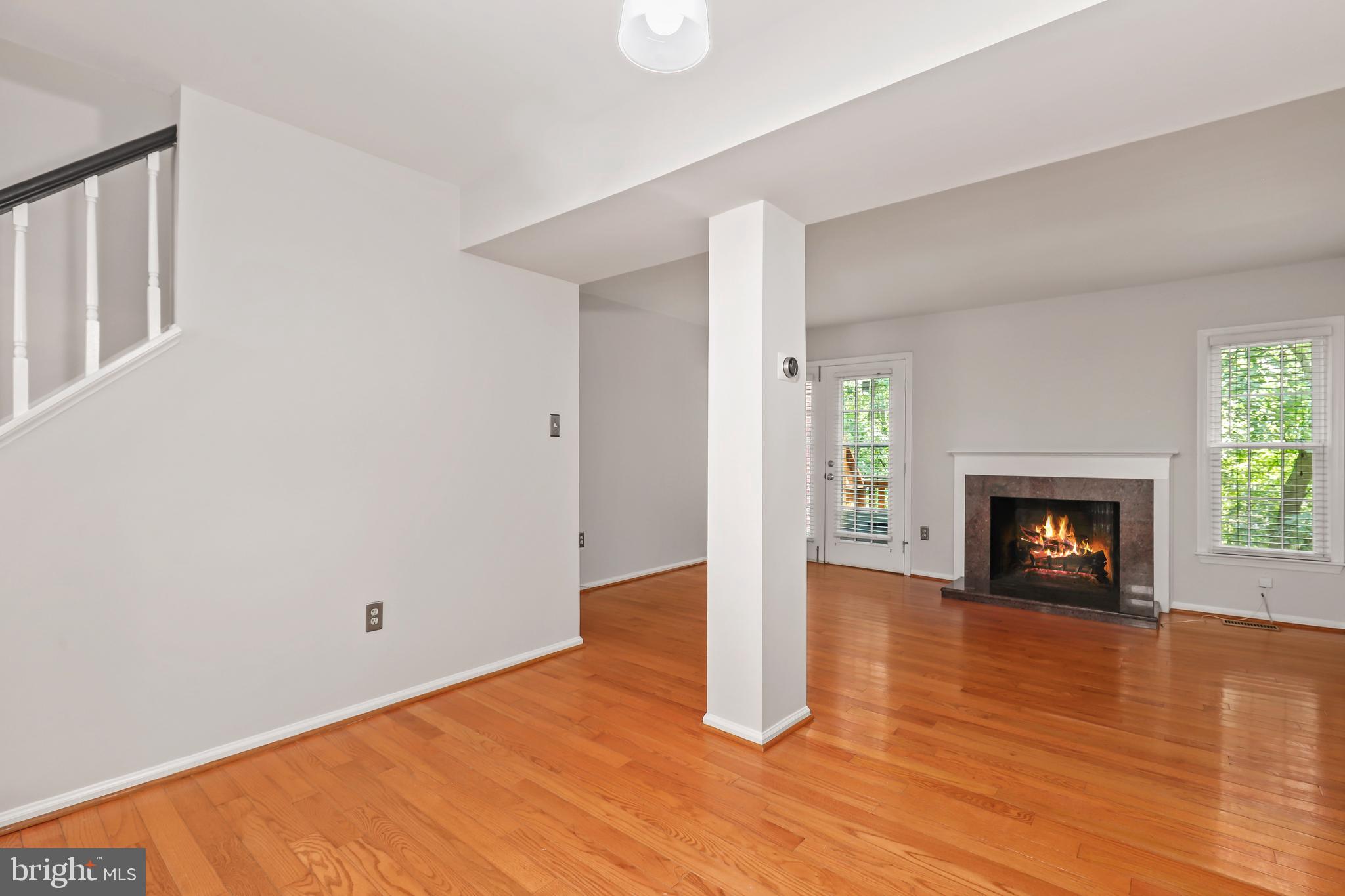 2434 South Walter Reed Drive, Unit 3 Arlington, VA 22206 - Photo 9 of 36 a view of an empty room with wooden floor fireplace and a window