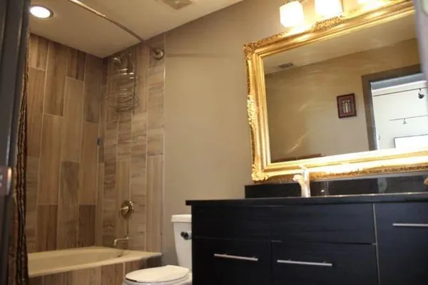 a bathroom with a granite countertop sink toilet and shower