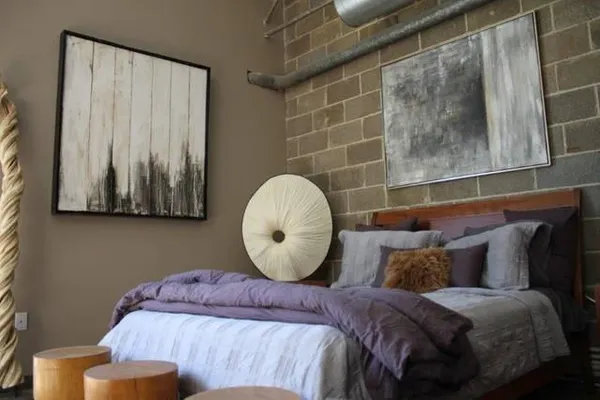 a bedroom with a bed and a painting on the wall