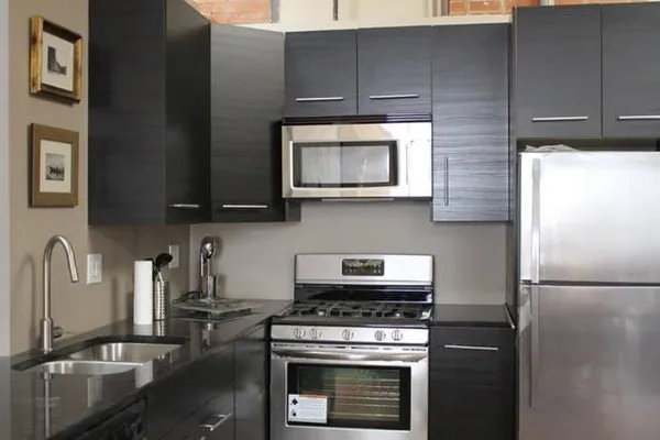 a kitchen with stainless steel appliances granite countertop a stove a refrigerator and a microwave