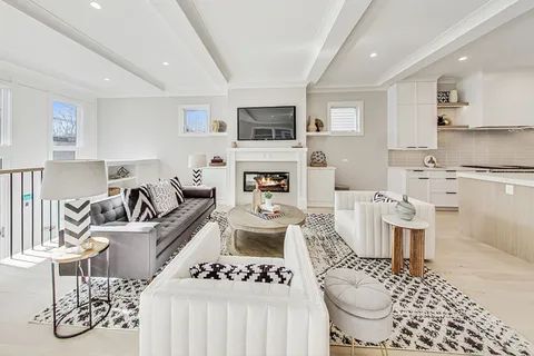 a living room with furniture a flat screen tv and kitchen view