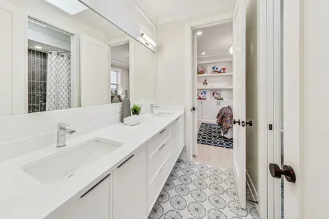 a spacious bathroom with a double vanity sink and mirror