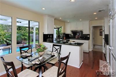 12522 Spring Creek Road Moorpark, CA 93021 - Photo 11 of 20 a kitchen with a dining table chairs and refrigerator